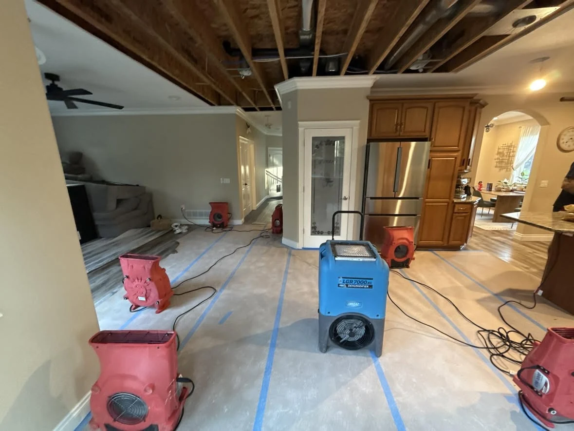 Portable air movers and dehumidifiers staged for emergency water mitigation
